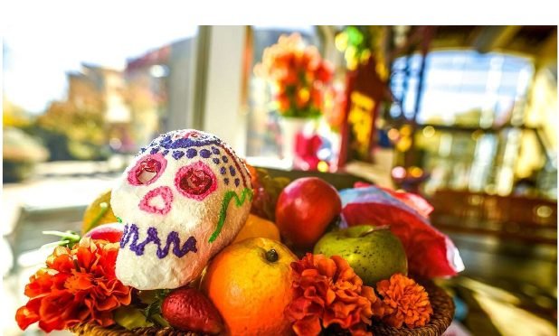 A Día de los Muertos offering of marigolds, fruit and a sugar skull